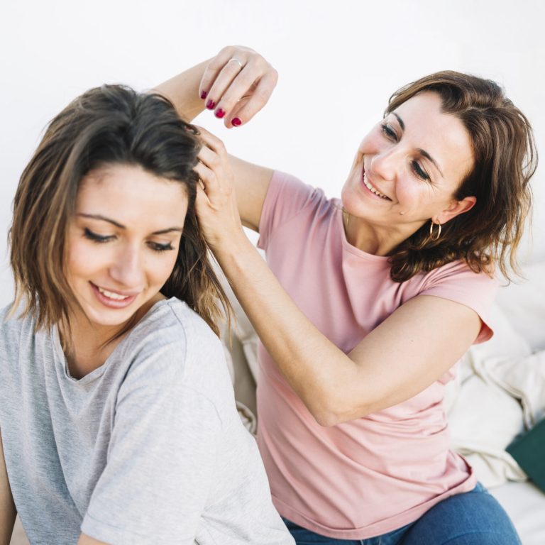 woman-braiding-hair-woman-sofa